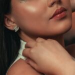 Wearing - A woman with green eyes and jewelry posing for a photo