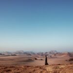 Vacation - a person standing in the middle of a desert