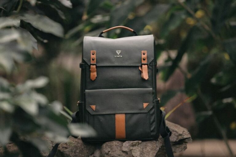 Bags - selective focus photography of black and brown leather backpack on rock