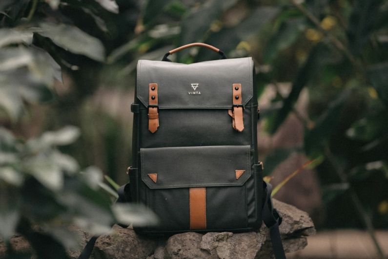Bags - selective focus photography of black and brown leather backpack on rock