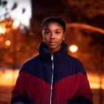 Outerwear - woman wearing red and black zip-up jacket standing