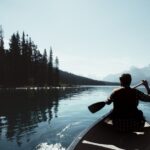 Exploring - man on canoe sailing on the river
