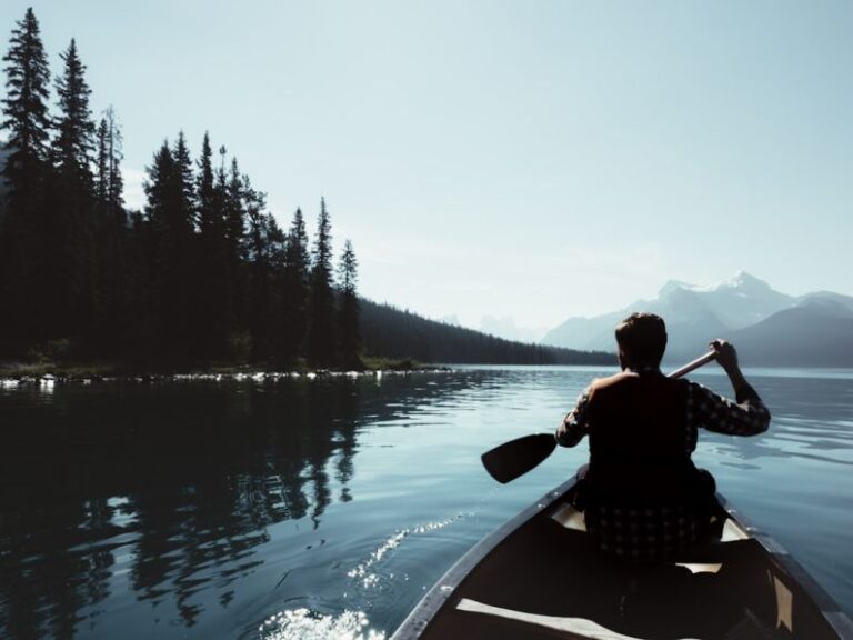 Exploring - man on canoe sailing on the river