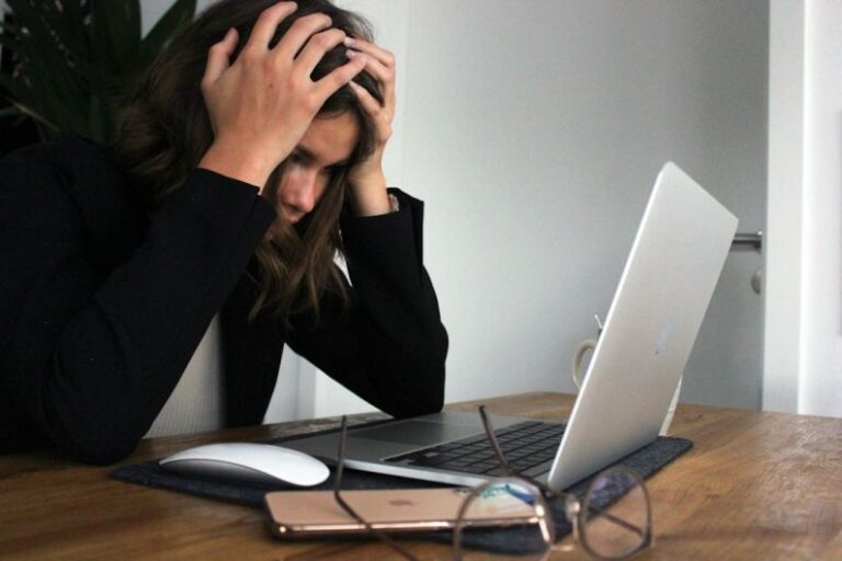 Stress - woman in black long sleeve shirt covering her face with her hands