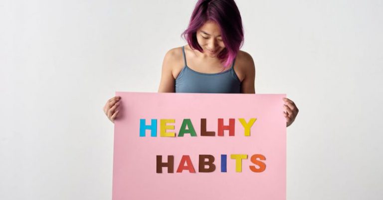 Healthy Habits - Woman Looking at the Pink Poster She's Holding