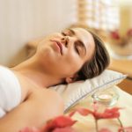 Beauty Treatment - Woman in Wrapped in White Towel Lying on Bed with Eyes Closed