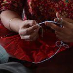 Knitting Basics - A woman is knitting a ball of yarn with a needle