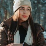 Clothes Alteration - A woman in a winter jacket leaning against the hood of a car