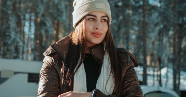 Clothes Alteration - A woman in a winter jacket leaning against the hood of a car