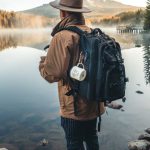 Travel Photography - Man in Brown Jacket and Brown Hat Standing on Rock Near Lake