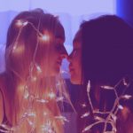 Romantic Getaways - two woman facing each other with string lights