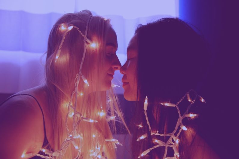 Romantic Getaways - two woman facing each other with string lights