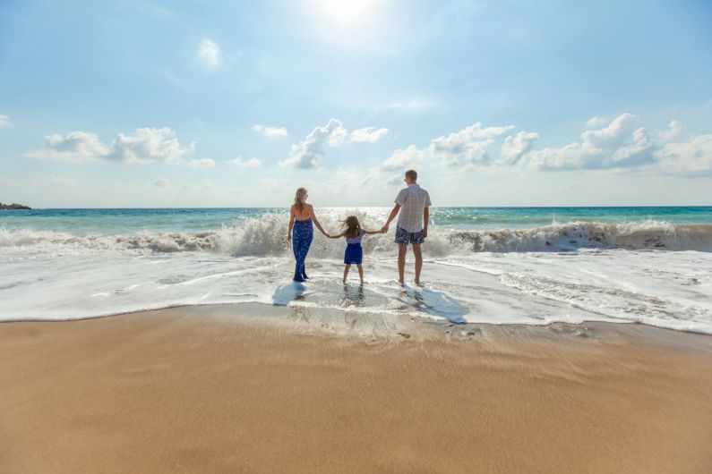 Family Vacation - man, woman and child holding hands on seashore
