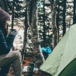 Outdoor Adventure - woman sitting and holding cup of coffee