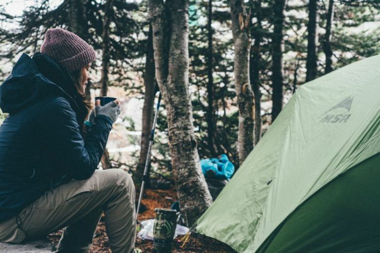 Outdoor Adventure - woman sitting and holding cup of coffee
