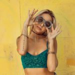 French-girl Fashion - woman in blue bralette holding sunglasses putting on her eyes