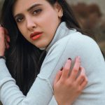 Makeup Finishes - A woman in a white sweater is posing for a portrait