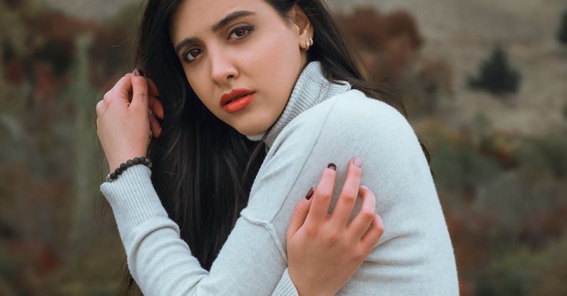 Makeup Finishes - A woman in a white sweater is posing for a portrait