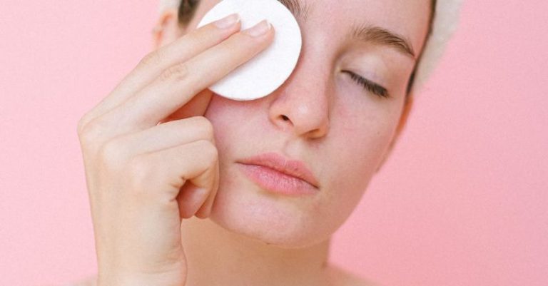 Makeup Removal - Woman removing eye makeup with cotton pad