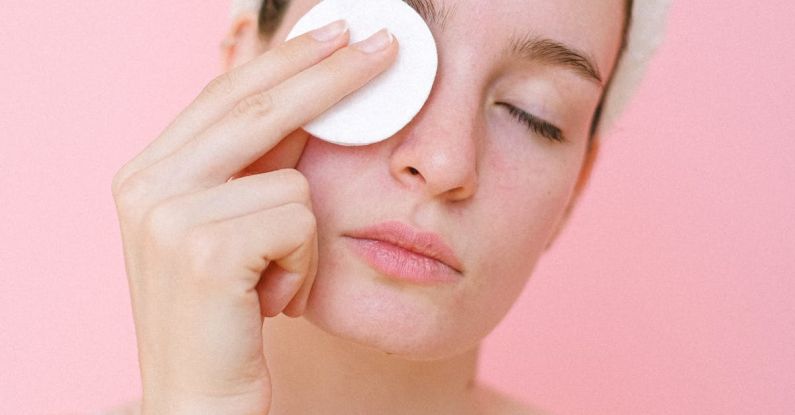 Makeup Removal - Woman removing eye makeup with cotton pad
