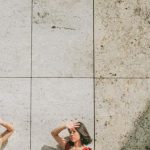 Sun Protection - Photo of Two Women Standing by Wall Posing While Blocking Sun with Their Hands