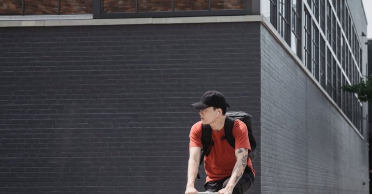 Healthy Cities - Man in Orange T-shirt Riding on Bicycle