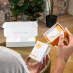 Energy Vitamins - Photo of a Woman Holding a Package with Supplements