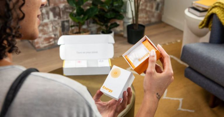 Energy Vitamins - Photo of a Woman Holding a Package with Supplements
