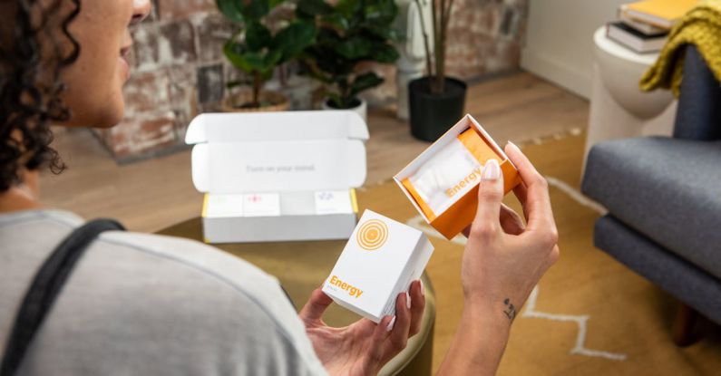 Energy Vitamins - Photo of a Woman Holding a Package with Supplements