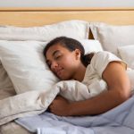 Sleep Quality - A woman sleeping in a bed with a blanket