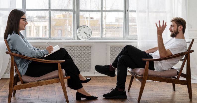 Mental Health Resources - Person in Black Pants and Black Shoes Sitting on Brown Wooden Chair