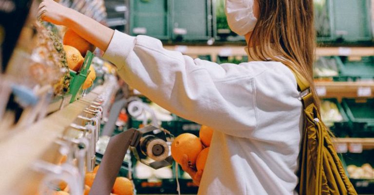 Health Food Stores - Woman in White Long Sleeve Jacket Shopping For Fruits