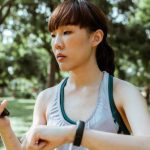 Wellness Apps - Concentrated young Asian woman using smartphone in park