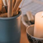 Aromatherapy Benefits - A table with candles, a bowl of chocolate and a spoon