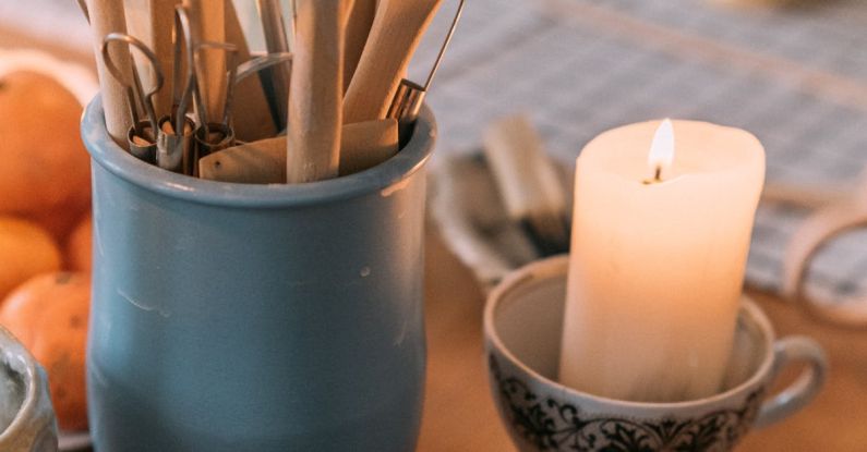 Aromatherapy Benefits - A table with candles, a bowl of chocolate and a spoon